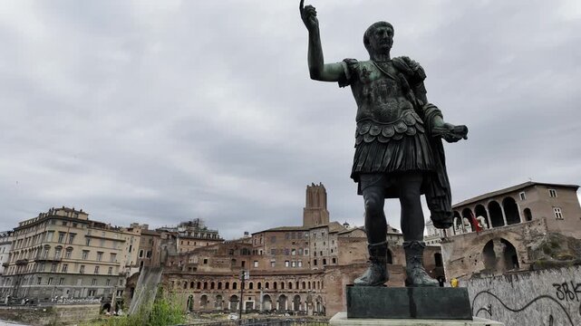 Majestic bronze statue of Roman Emperor Trajan in armor, set against the historic brick ruins of Trajan's Market in Rome, Italy. A powerful symbol of ancient Roman heritage and classical architecture.
