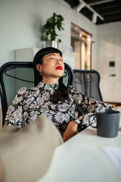 Tired businesswoman resting at desk in modern office