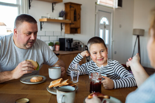 Father and son enjoying breakfast in home kitchen