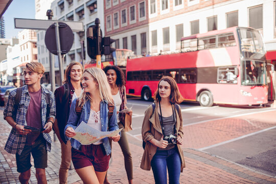 Young tourists sightseeing on city street with red double-decker bus