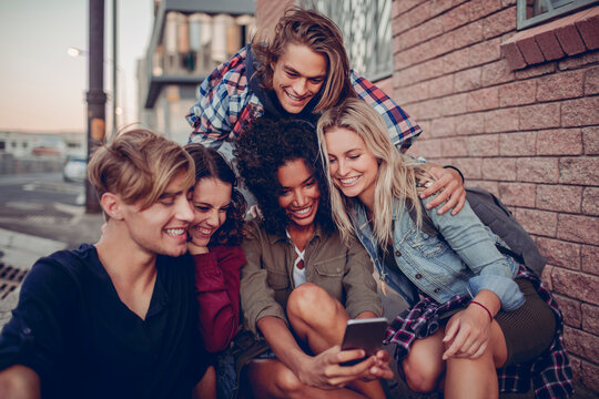 Group of young friends taking a selfie on city street
