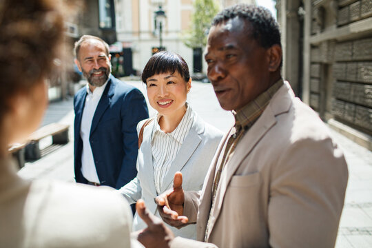 Diverse business professionals networking on city street