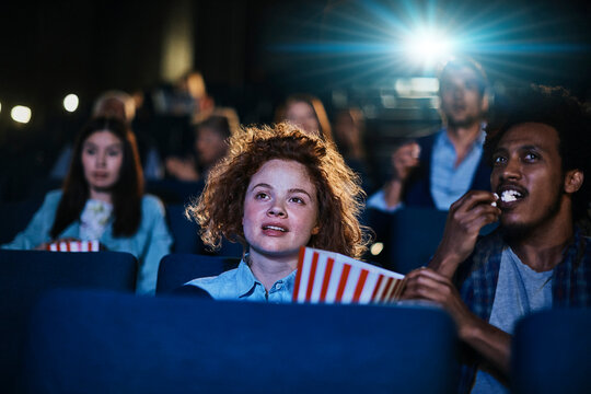 Young adults watching movie in cinema theater