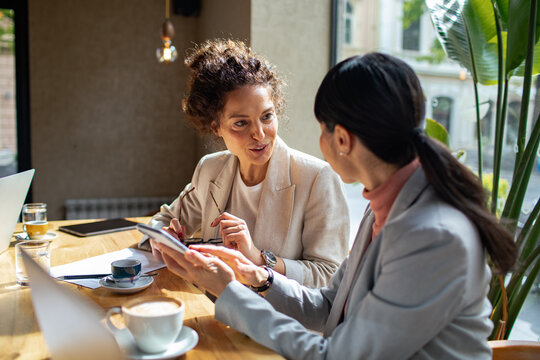 Two businesswomen discussing project in a cafe