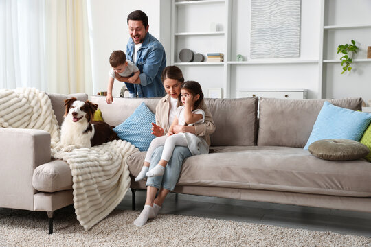 Happy family and their dog on sofa at home