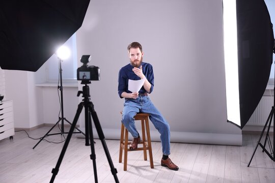 Actor with script rehearsing on light grey background