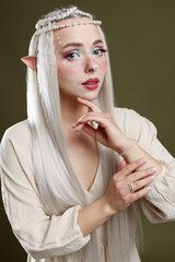 Fototapeta premium Beautiful elf girl on dark olive background