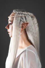 Fototapeta premium Beautiful girl dressed as elf on grey background