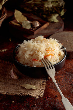 Sauerkraut with ingredients on a rustic background.
