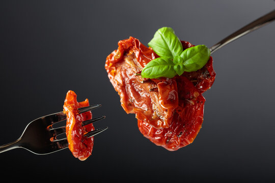 Sun dried tomatoes in olive oil with green basil.
