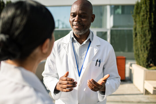 Doctor consulting with colleague outside hospital building