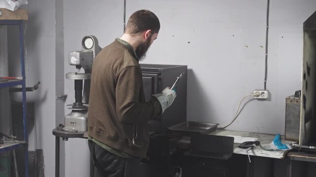 Blacksmith places knife into furnace during quenching