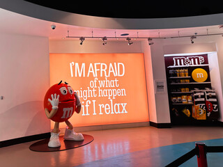 Naklejka premium Red M and M mascot in a bright shop display with illuminated sign reading I'm afraid of what might happen if I relax at an M and M store in London UK