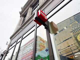 Naklejka premium Lego store facade with glass reflections and Big Ben detail in central London, UK, showing modern retail architecture and iconic city landmark in window reflection