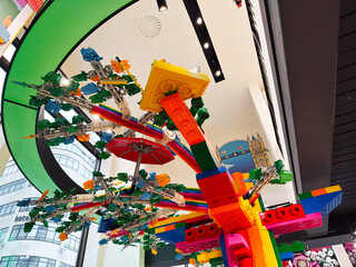 Naklejka premium Colorful LEGO sculpture installation in London UK store featuring giant rainbow tree, aerial models and playful architectural display that inspires children and tourists