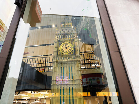 Model of Big Ben clock tower displayed in a shop window with reflections in London, UK - ornate souvenir and architectural replica in retail storefront