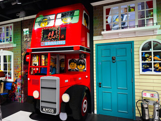 Naklejka premium Bright Lego double decker bus installation inside a toy store facade in London UK with playful characters, colorful bricks, family friendly display and interactive children's attraction