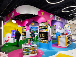 Naklejka premium Colorful LEGO toy store display in London UK with children playing and family shoppers in a vibrant kids retail area full of toys and interactive exhibits