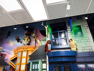 Fototapeta premium Colorful LEGO owl and wizard shop display in a London UK toy store window made of giant bricks and playful figures lighting up a family friendly retail experience