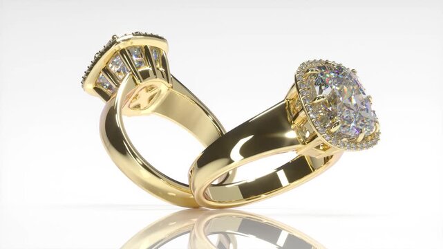 Rotation of gold engagement rings with large cushion cut diamond and round diamonds on white background. 3d animation loop