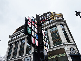 Naklejka premium Historic building facade with Swiss Court heraldic shields and ornate hanging sign in central London, UK, classical columns clock and dome on a commercial street corner