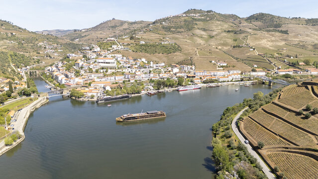 Aerial view of Pinhao town nestled along the Douro river with terraced vineyards and cruise boats Pinhao, Vila Real, Portugal.
