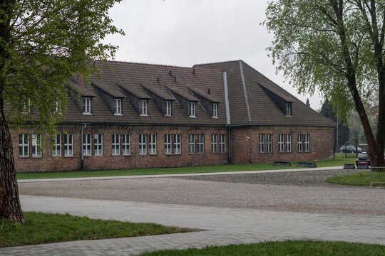 Historic brick barracks at Auschwitz I concentration camp in Oswiecim, Poland. Holocaust memorial site and museum building under a grey sky. Oswiecim, Poland - April 21, 2026.