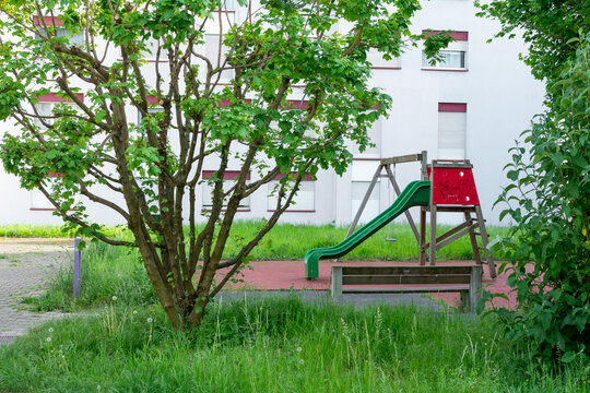 Aire de jeux pour enfants dans une r&eacute;sidence urbaine avec toboggan et verdure
