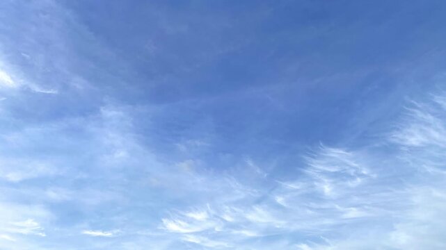 Blue sky seamless loop stop motion animation with random soft white cloud patterns. 4K animated blue sky for background, video editing, nature content, presentations, and motion graphics.