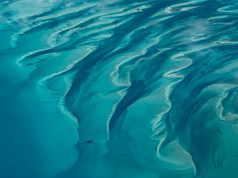 The Bahamas - aerial landscape view of turquoise water surface and small atolls of Bahamas, with ripple surface,  located in the Caribbean Sea in Atlantic Ocean.