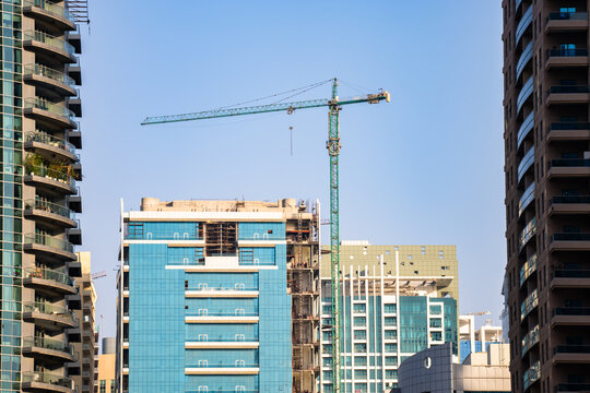Modern construction site with new residential buildings under development, showing cranes, scaffolding, and workers, representing urban growth, infrastructure expansion, and real estate development.