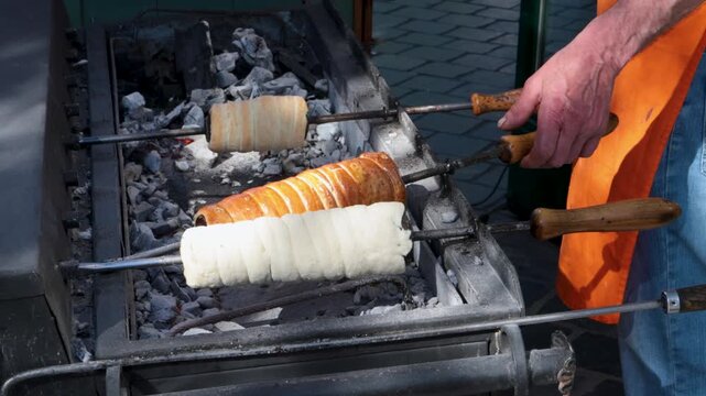 Golden Brown Chimney Cakes Being Cooked over Hot Coals in Budapest, Hungary