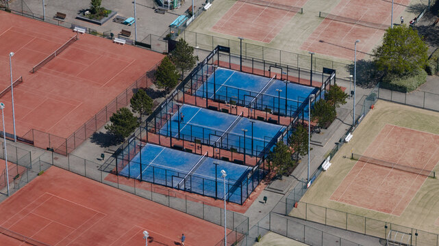 Aerial view of Tennis Padel Club Heiloo featuring blue padel courts and red clay tennis courts with players in Heiloo, Noord-Holland, Netherlands.