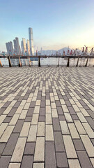 Fototapeta premium Hong Kong skyline with construction cranes and waterfront promenade at sunrise