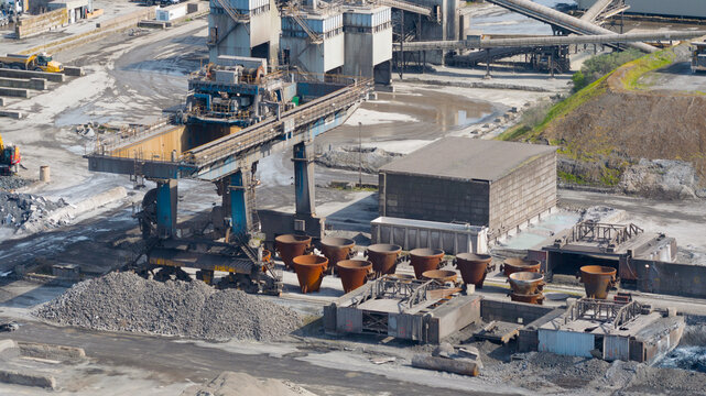 Aerial view of the Tata Steel industrial plant featuring heavy machinery, metal ladles, and raw material piles in Velsen-Noord, Noord-Holland, Netherlands.