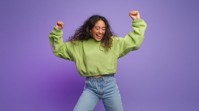 緑のスウェットを着て楽しそうに踊る女性。ポップで明るい雰囲気のライフスタイルイメージ