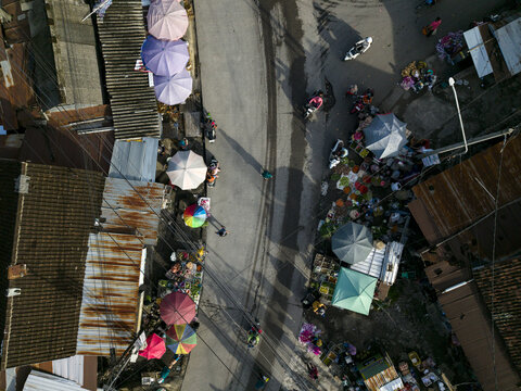 Aerial view of Pasar Kembang Klaten traditional market with colorful umbrellas, street stalls, and motorbikes on the road Klaten, Central Java, Indonesia.