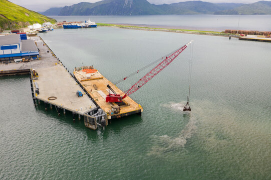 Aerial view of crane on floating platform in the bay of Unalaska, Alaska, USA.