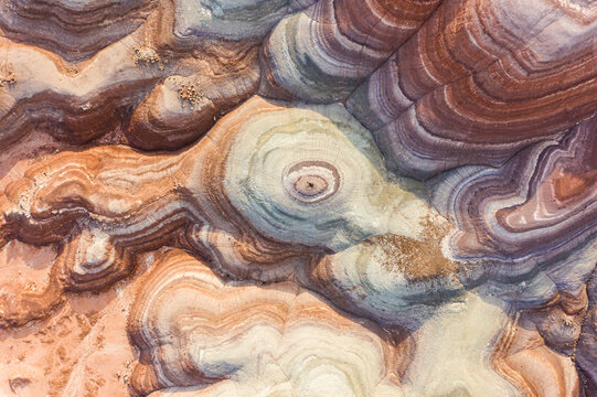 Aerial view of man laying on rock formations in Hanksville, Utah, USA.