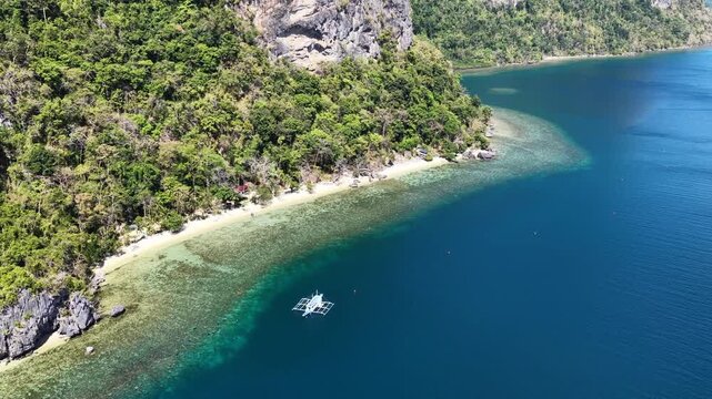 A beautiful beach is fringed by a coral reef on a remote island in El Nido, Philippines. This scenic area of Palawan is a popular vacation destination due to its reefs, beaches, and rock islands.
