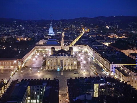 Aerial view of the illuminated Piazza Castello and Palazzo Madama at night with the Mole Antonelliana spire in the distance Turin, Piedmont, Italy.