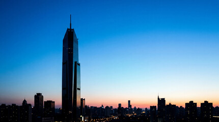 Obraz premium Sleek Glass Skyscraper Silhouette Against Clear Blue Gradient Sky Modern Architecture Photography For Branding