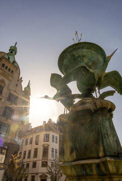 The iconic Stork Fountain in Copenhagen, Denmark, captured in the golden sunlight along Stroget, showcasing stunning architecture and vibrant city life.