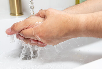 Fototapeta premium Washing Hands Under Running Water in Bathroom Sink