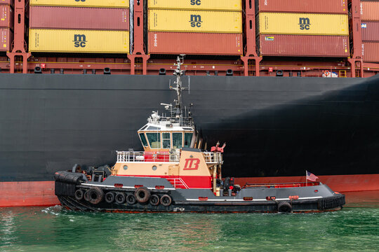 Boston, MA, US-April 25, 2026: Large international cargo ships in harbor  loaded with shipping containers.