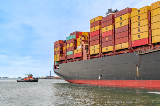 Boston, MA, US-April 25, 2026: Large international cargo ships in harbor  loaded with shipping containers.