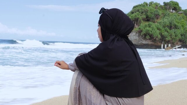 Serene moment of a modest woman reflecting by the sea shore during summer vacation.