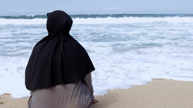 Serene moment of a modest woman reflecting by the sea shore during summer vacation.