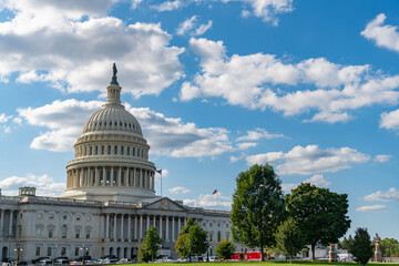 Naklejka premium Famous Capitol in Washington DC. Washington DC landmark. Senate and House in Washington DC. Capitol dome. Historic Capitol by the national flag. Capitol dome as symbol of law