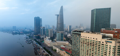 Fototapeta premium Ho Chi Minh City, Vietnam - An aerial view of the Saigon River and the city skyline, featuring the Landmark 81 tower and Times Square building.